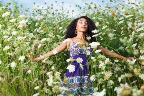 amor próprio mulher negra em um campo de flores