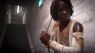 Película estadounidense: Adelaide en un pasillo oscuro con ropa rasgada cubierta de sangre