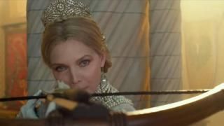 Malévola: Mistress of Evil Filme: Rainha Ingrith mirando uma besta carregada