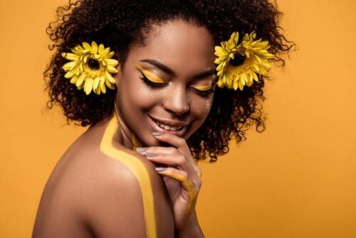 prekrasna crna djevojka sa žutim cvijećem u kosi pozira za fotografiju s brojem anđela 4444