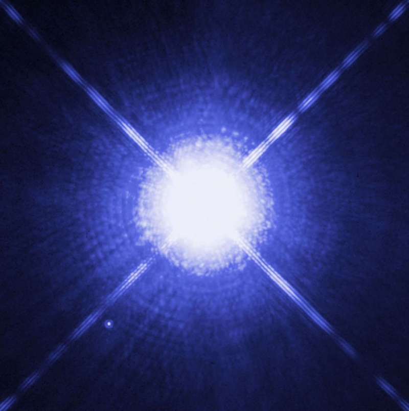 Imagem do Hubble de uma das estrelas binárias mais próximas do Sol: Sirius A (centro) e sua anã branca companheira B (no canto inferior esquerdo); A é aproximadamente 10.000 vezes mais brilhante.