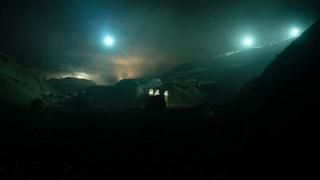 Another Life Television Scene 3: Uma paisagem sombria mostra as luzes brilhantes de uma nave espacial com três pequenos astronautas no solo.