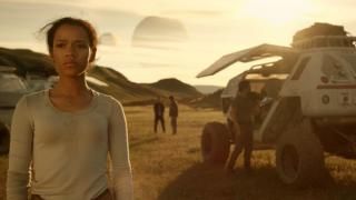 Kaotatud kosmosesarjas: noor tüdruk seisab teispoolsuse kõrbemaastikul; tema taga on kolm inimest ja kosmosesõiduk.