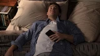 Jexi Movie: Phil ligger i sengen og holder sin telefon
