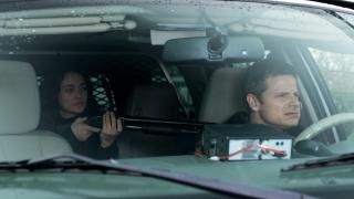 The Crossing TV Series: Мъж кара кола, докато жена седи на задната седалка, държайки пушка заплашително върху себе си.