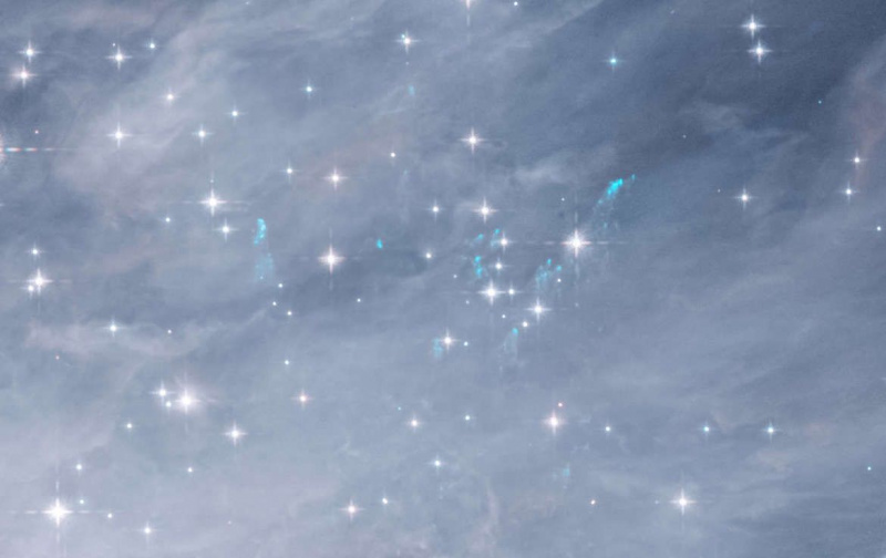 As balas de gás podem ser vistas como manchas azuis esmaecidas, lançadas de estrelas jovens massivas interagindo na nebulosa de Órion. Crédito: NASA / ESA / Massimo Robberto / Judy Schmidt