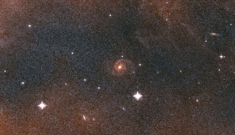 Centenas de milhares de vezes mais longe, uma galáxia espiral espia fora do gás e poeira na nebulosa de Órion. Crédito: NASA / ESA / Massimo Robberto / Judy Schmidt
