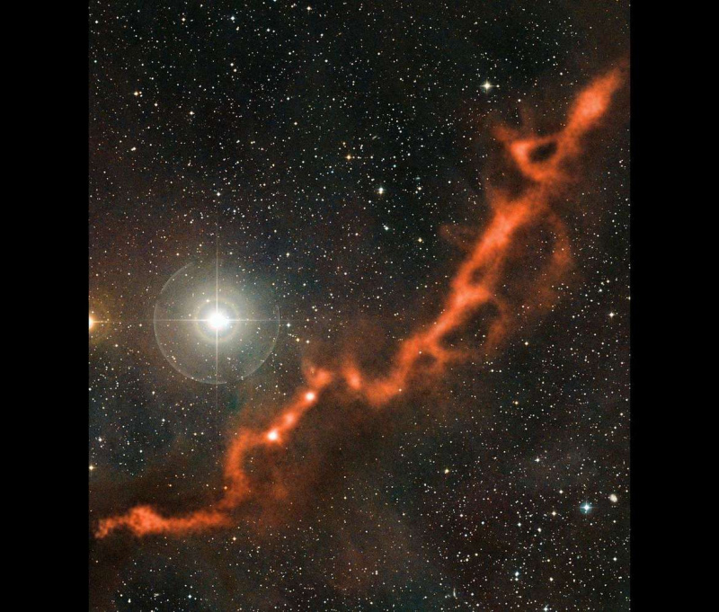 Το φωτεινό αστέρι Phi Tauri λάμπει σε ορατό φως (μαζί με χιλιάδες άλλα αστέρια) ενώ ένας ποταμός κρύου αερίου και σκόνης λάμπει σε χιλιοστά μήκη κύματος σε αυτήν την εικόνα που αποτελείται από δύο υπερτιθέμενες παρατηρήσεις.